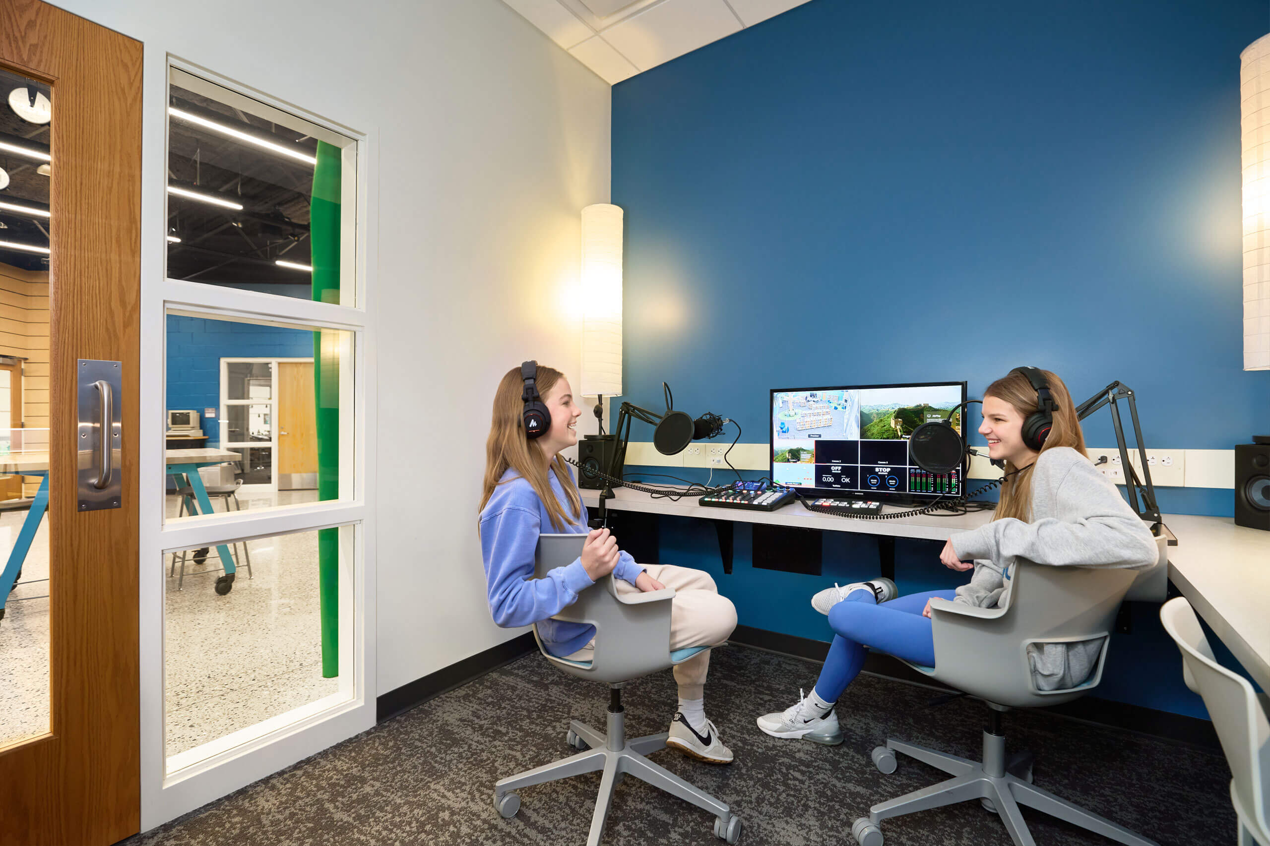 two students seated in front of recording equipment in Ada Christian School maker space recording booth