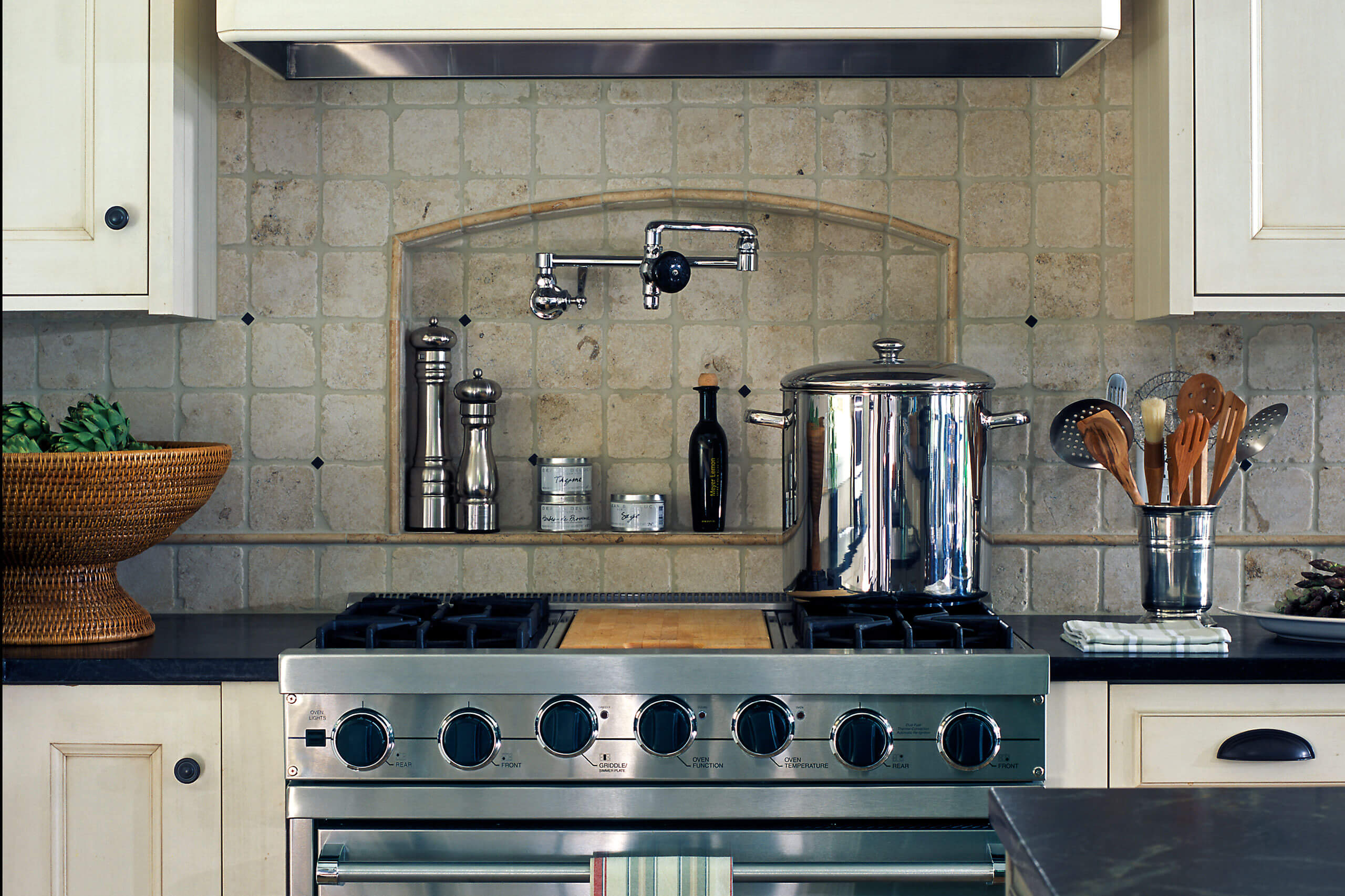 kitchen stovetop with stone backsplash