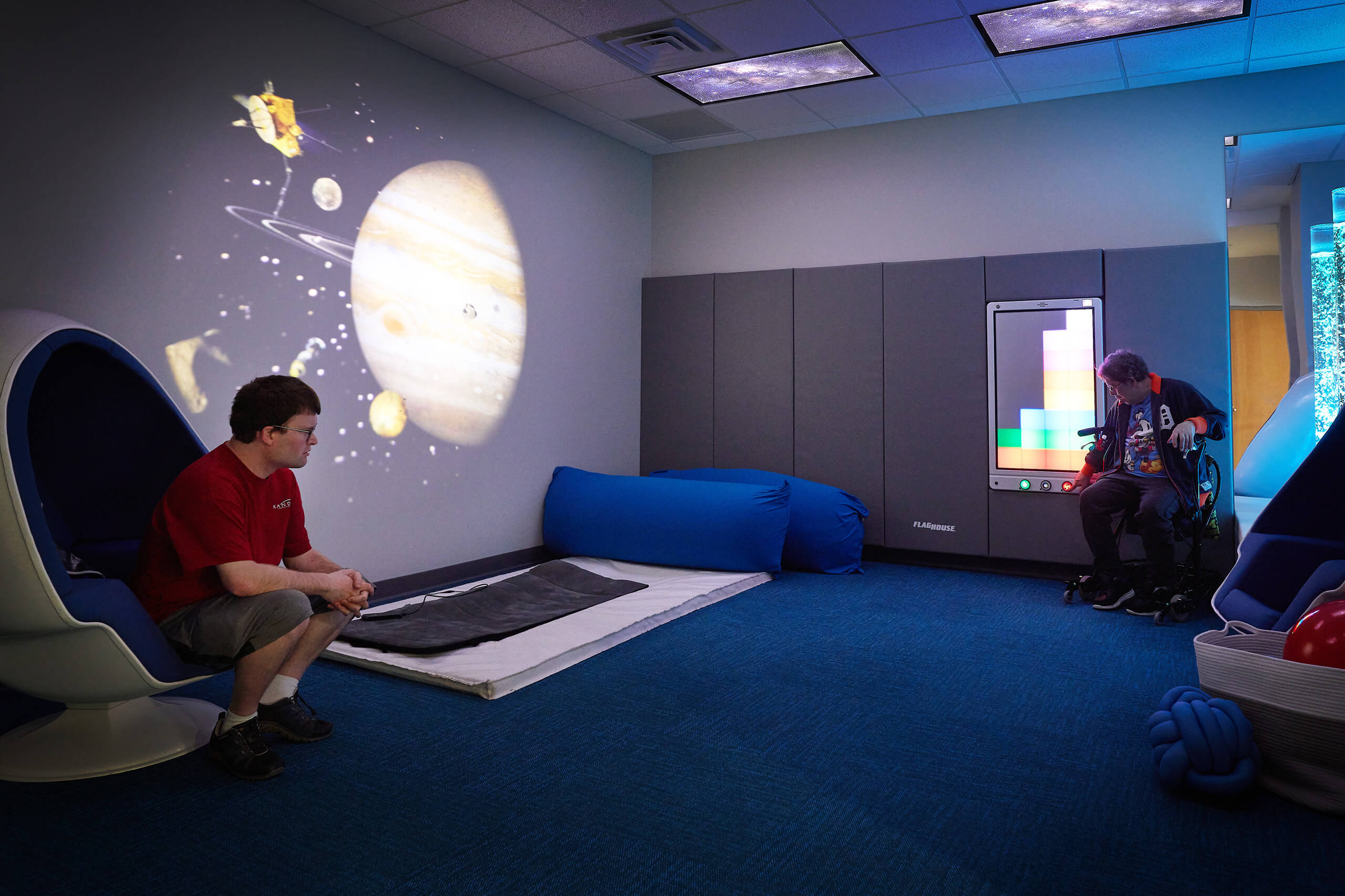 two people sitting on opposite sides of a sensory therapy room
