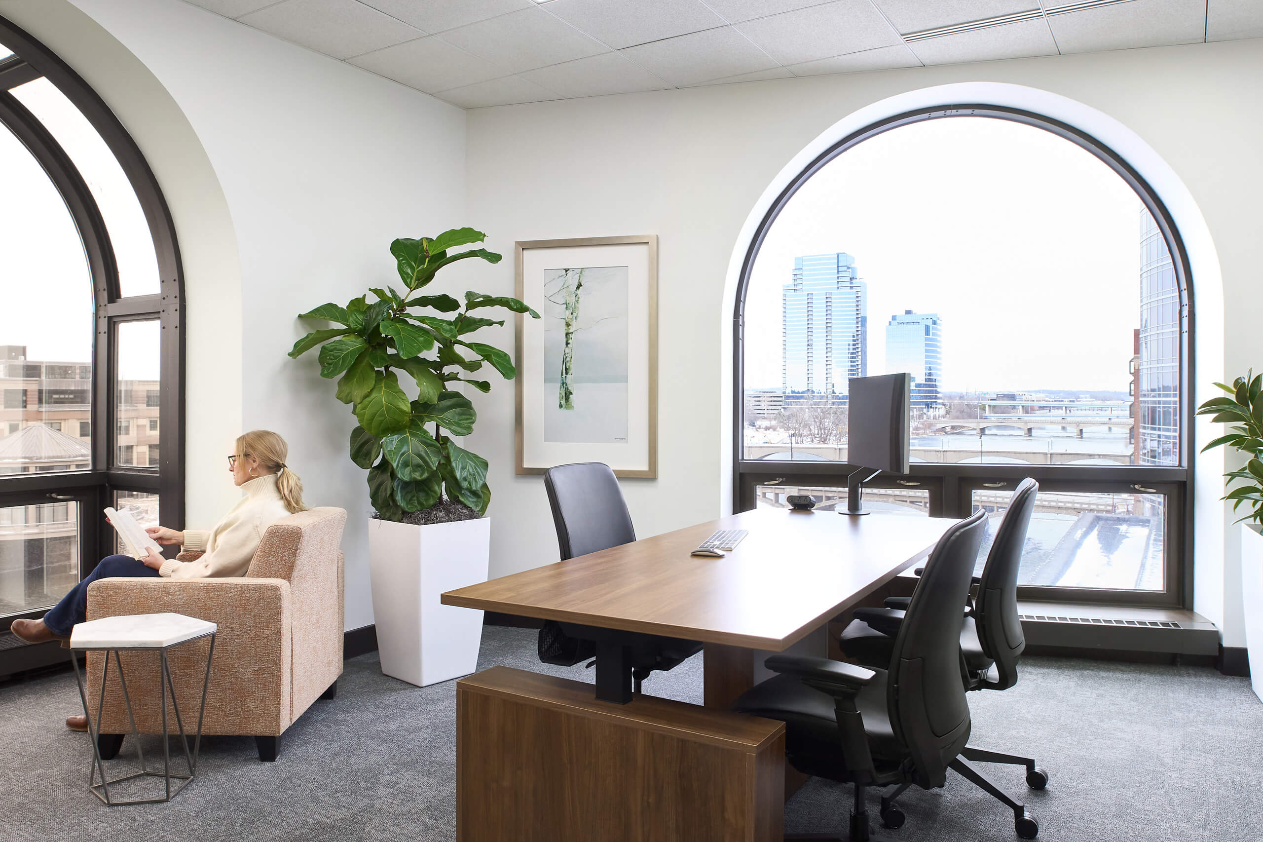 private office with height-adjustable desk and large windows overlooking river