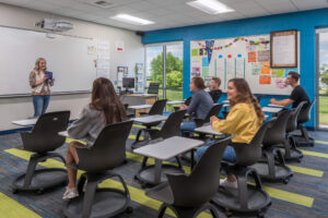 students sitting in a classroom at movable desks