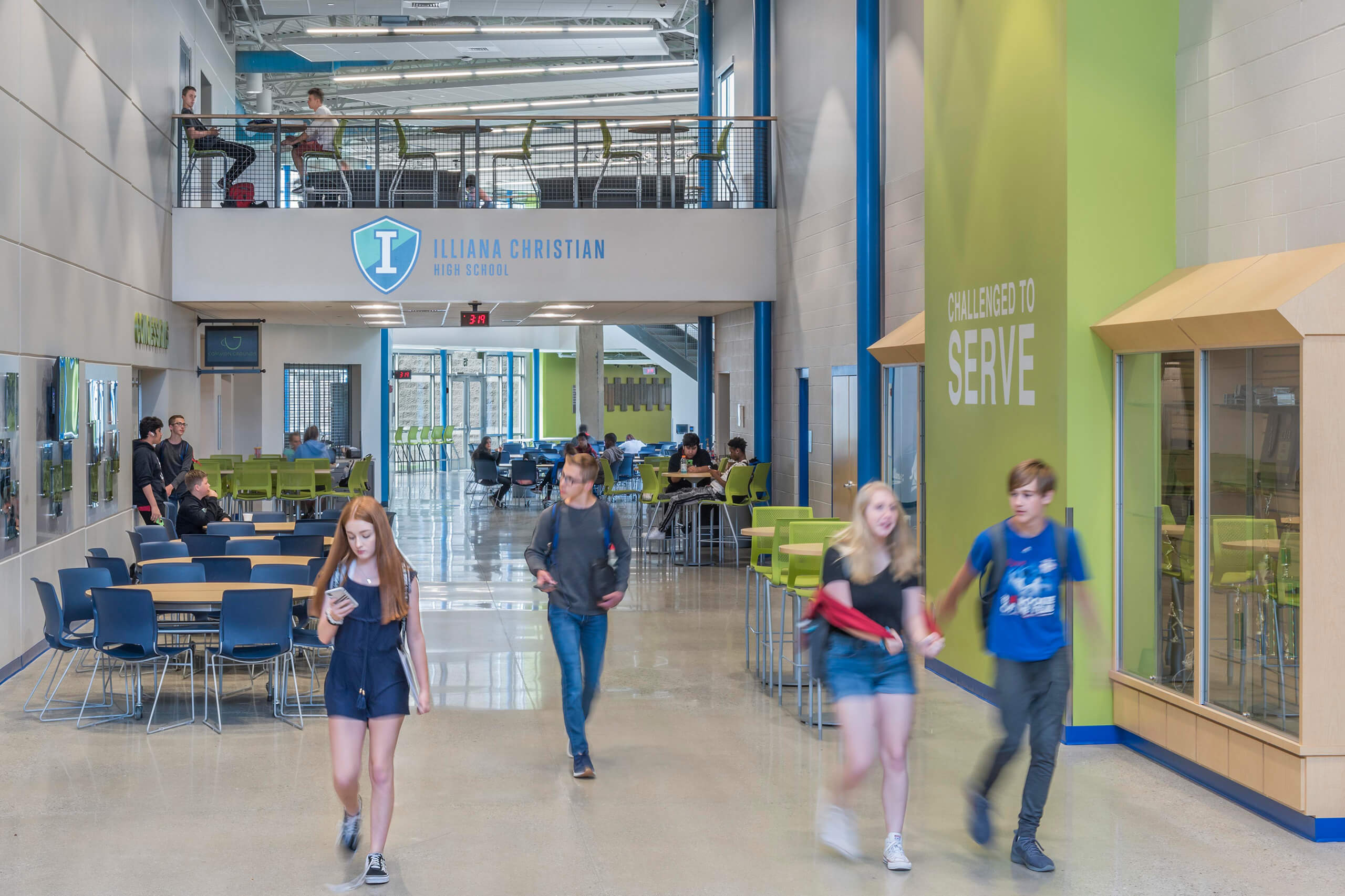 students walking through a large hallway with overlooking walking bridge