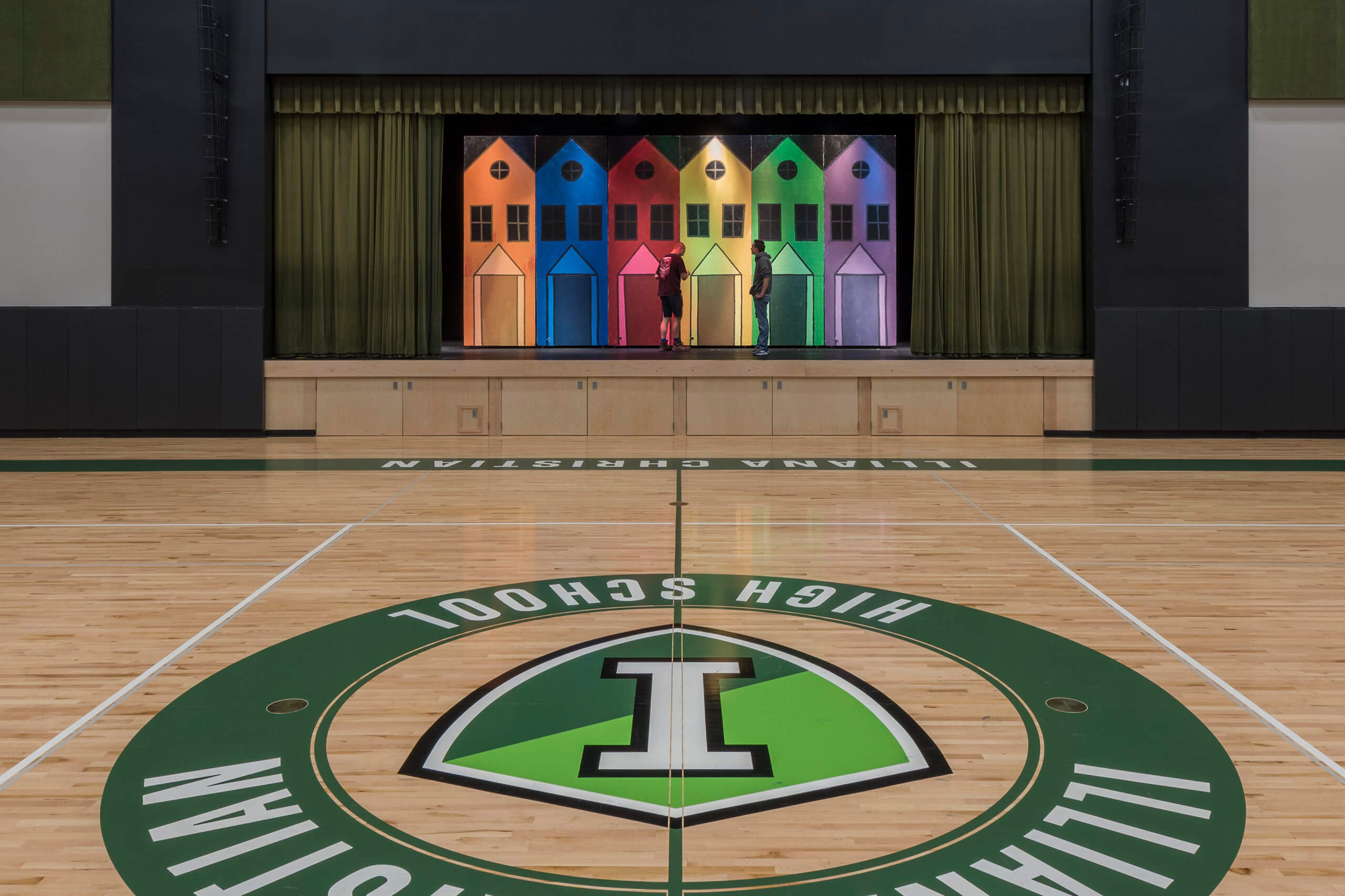 colorful row house backdrop on performance stage along one edge of a gymnasium