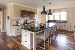 interior kitchen with center island and feature bronze hood vent over stove