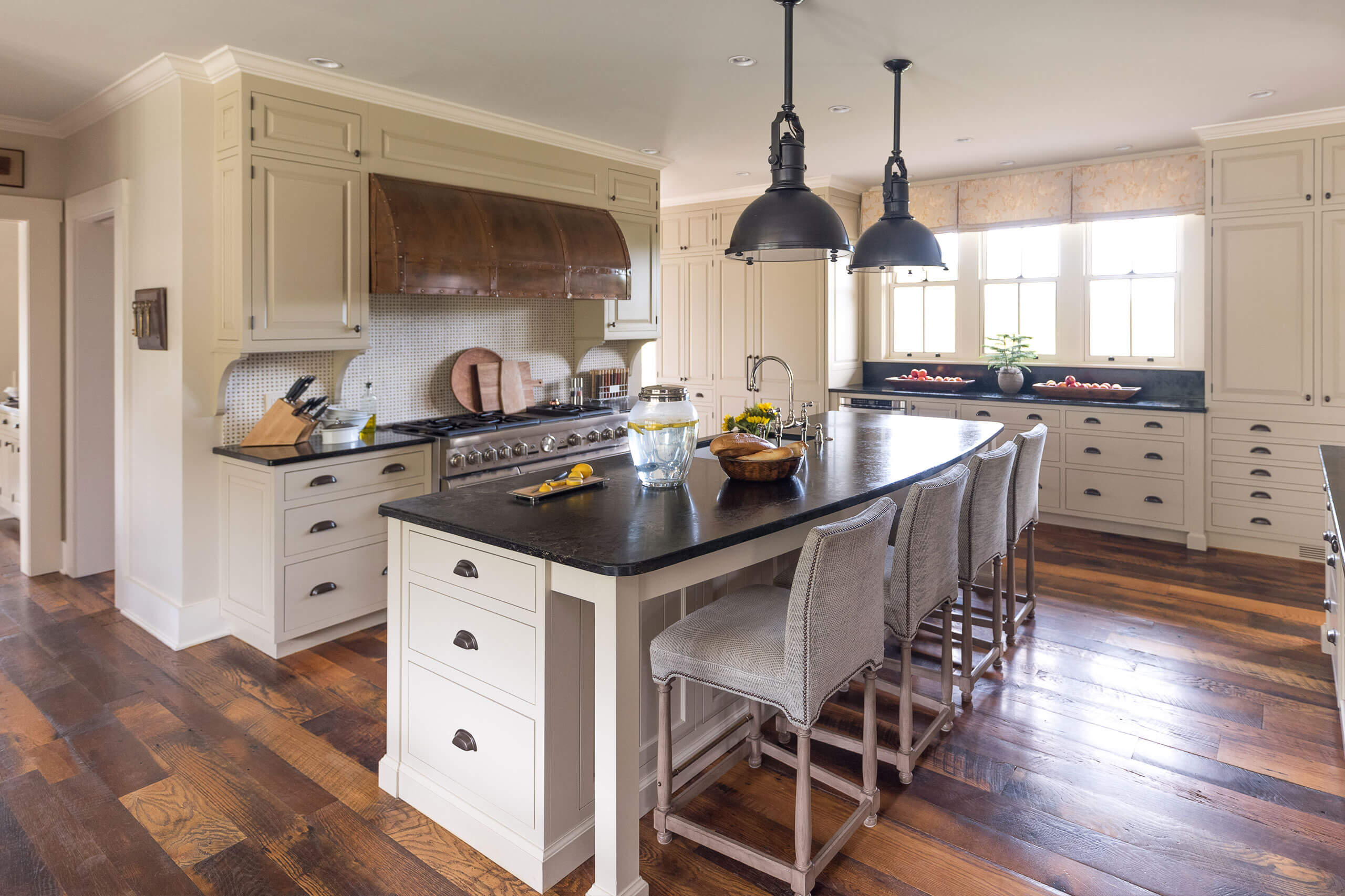 interior kitchen with center island and feature bronze hood vent over stove
