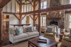 interior living room with stone fireplace and exposed wood beams
