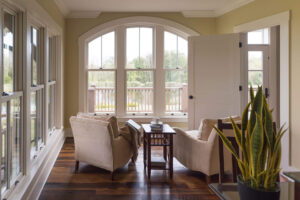 sitting area overlooking a pond with lots of windows and natural light