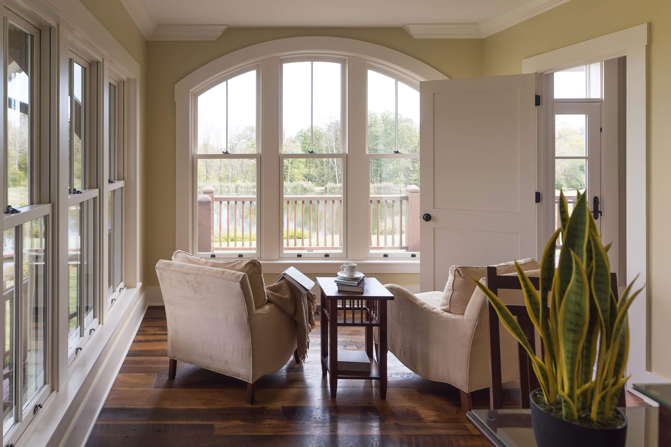 sitting area overlooking a pond with lots of windows and natural light